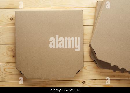 Pizza geschlossene Kartonbox auf natürlichem Holztisch, flaches Modell mit Kopierraum Stockfoto