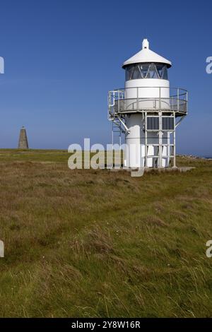 Roseness Leuchtturm mit Küste und Fußweg in der Heide, hinter Steinmarkierungen aus dem Jahr 1867, Halbinsel Cornquoy, Festland Orkney, Schottland, Großbritannien Stockfoto