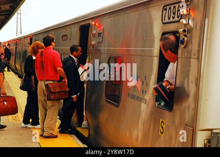 Ein Zugbegleiter der Long Island Railroad wartet auf Pendler, die im Rockville Centre, New York, in den Zug steigen, um ihre Arbeit in New York City zu erledigen Stockfoto