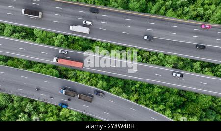 Draufsicht von Pkw und LKW, die auf der Autobahn in grünem Wald fahren. Nachhaltiger Verkehr. Drohnenansicht von Wasserstoff-Energie-Lkw und -Elektrik Stockfoto