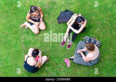 Gruppe von jungen Studenten sitzen am Ufer an Göring Schleuse Goring-on-Thames, Oxfordshire, England, Vereinigtes Königreich Stockfoto