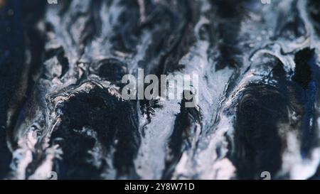 Farbmischkurve. Glitzerfarbe tropft. Unschärfe blau weiß schwarz schimmernde Farbe Öl Textur magische Tropfen Fluss abstrakte Kunst Hintergrund. Stockfoto