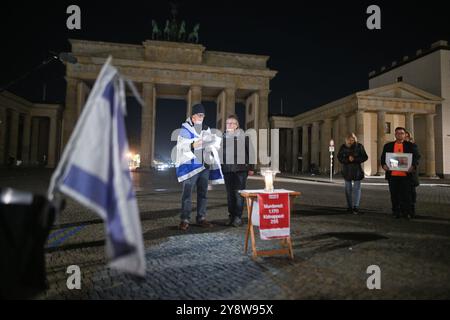 Berlin, Deutschland. Oktober 2024. Die Namen der Opfer des Massakers der Hamas am 7. Oktober 2023 werden während der Mahnwache "Never Forget 7th Oktober" vor dem Brandenburger Tor vorgelesen. Quelle: Sebastian Christoph Gollnow/dpa/Alamy Live News Stockfoto