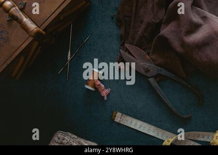 Stillleben aus alten Schneiderwerkzeugen und Accessoires wie Schere, Maßband, Ledergewebe, Nähkästchen in Szene. Nähen von Zubehör Stockfoto