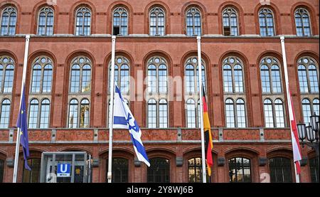 Berlin, Deutschland. Oktober 2024. Die Fahnen vor dem Roten Rathaus in Berlin hängen am Halbmast zum Jahrestag des 7. Oktober 2023. Am 7. Oktober 2023 verübten Terroristen aus dem Gazastreifen ein Massaker in Israel, bei dem über 1.200 Menschen getötet und rund 250 Geiseln genommen und entführt wurden. Quelle: Katharina Kausche/dpa/Alamy Live News Stockfoto