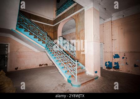 Elegante, aber verlassene Treppe in einem verwitterten Gebäude. Stockfoto