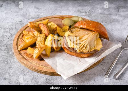 Hamburger mit Austernpilzen und Cheddar auf einem Holzschneidebrett Stockfoto