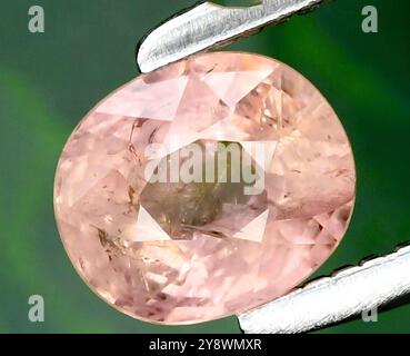 Exquisiter rosafarbener ovaler Edelstein in künstlerischen Details. Stockfoto