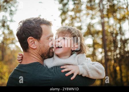 Vater und Mädchen beim Spaziergang im Herbstwald. Dad und Mädchen haben Spaß im Freien. Stockfoto