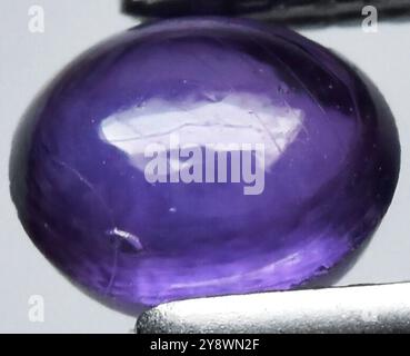 Fesselnder Amethyst Edelstein mit sattem violetten Farbton und komplexen Oberflächendetails. Stockfoto