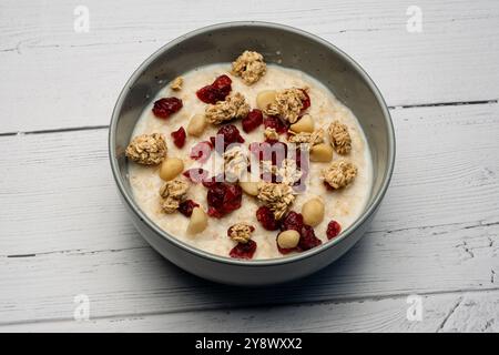 Traditionelles schottisches Frühstück mit einem modernen Touch einer Schüssel mit traditionellem Haferbrei gefüllt mit Müslipinienkernen und Preiselbeeren. Stockfoto
