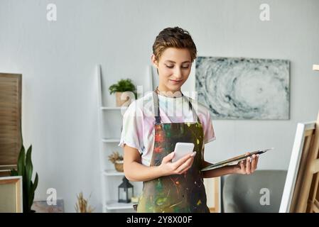 Zu Hause mischt eine junge Frau Farben und fängt Inspirationen ein, während sie ihre neueste Kreation malt. Stockfoto