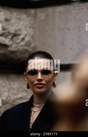 Polina Erofeeva mit komplett schwarzem Outfit kombiniert mit einem übergroßen Blazer, Minirock, Stiefeln und einem birkin auf der Hermès Show in der Pariser Fashion Week SS25 Stockfoto