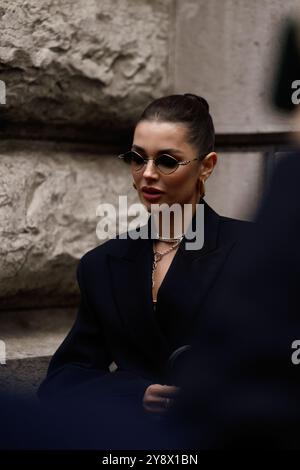 Polina Erofeeva mit komplett schwarzem Outfit kombiniert mit einem übergroßen Blazer, Minirock, Stiefeln und einem birkin auf der Hermès Show in der Pariser Fashion Week SS25 Stockfoto