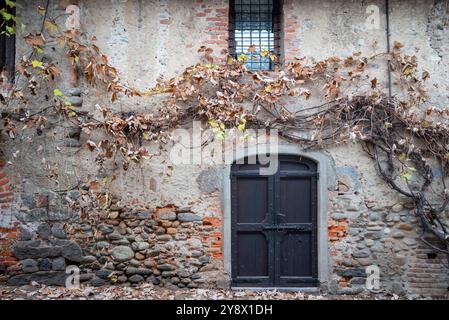 Italien, Rezept von Candelo. Panorama des mittelalterlichen Dorfes. Geschichte und Kultur Italiens und Europas. Isolierte Holztür im Vordergrund. Stockfoto