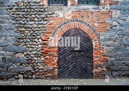 Italien, Rezept von Candelo. Panorama des mittelalterlichen Dorfes. Geschichte und Kultur Italiens und Europas. Isolierte Holztür im Vordergrund. Stockfoto