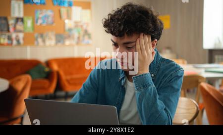 Müde gestresste Kopfschmerzen überarbeiteten traurig verärgert kaukasischer männlicher Student Guy Schüler Junge Teenager, der Laptop studiert und online Bildung Internet lernt Stockfoto
