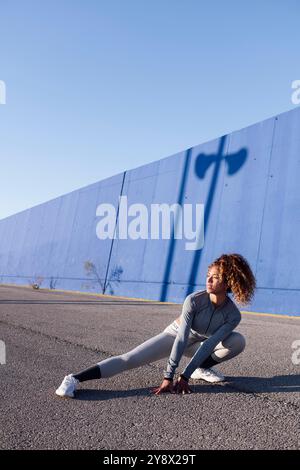 Athlet, der während des Trainings seitlich hockt Stockfoto