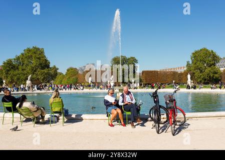 Paris, Frankreich 10.05.2024 Menschen entspannen sich am Teich im Tuileriengarten an einem sonnigen Herbsttag. Stockfoto