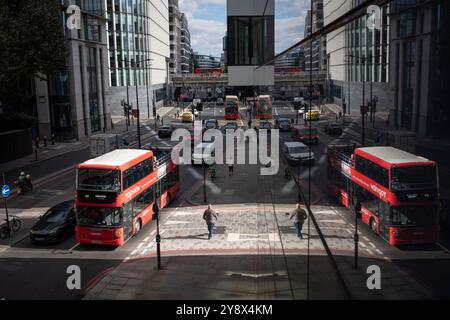 Ein Blick aus der Vogelperspektive über die Upper Thames Street in Richtung London Bridge, wo Verkehr und Fußgänger durch Schatten und Sonnenlicht in der City of London, dem historischen Finanzviertel der Hauptstadt (auch bekannt als „Square Mile“), am 4. Oktober 2024 in London, England. Stockfoto