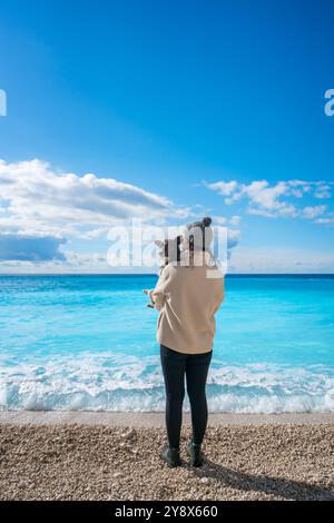 Frau mit Hund am Strand von Porto Katsiki mit türkisfarbenem Wasser Stockfoto