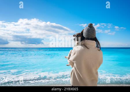 Frau mit Hund am Strand von Porto Katsiki mit türkisfarbenem Wasser Stockfoto