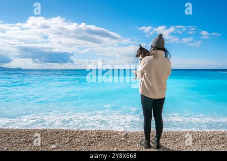 Frau mit Hund am Strand von Porto Katsiki mit türkisfarbenem Wasser Stockfoto