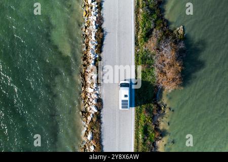 Blick von der Drohne auf einen Wohnmobil auf einer Straße zwischen zwei Seen Stockfoto