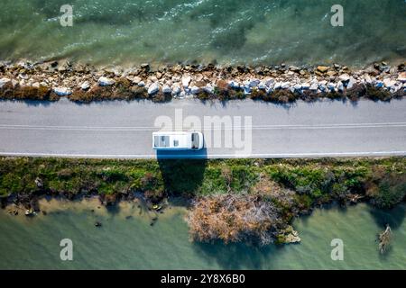 Blick von der Drohne auf einen Wohnmobil auf einer Straße zwischen zwei Seen Stockfoto