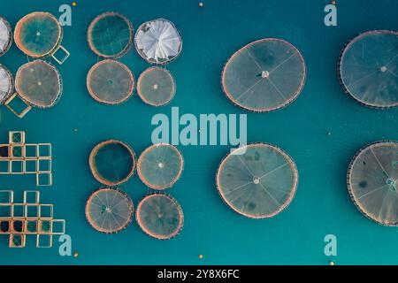 Blick von der Drohne auf schwimmende runde Fischfarmen auf dem Meer von Griechenland Stockfoto