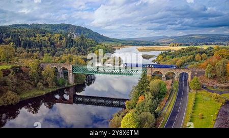 ScotRail Zug auf dem Shin Railway Viaduct mit Kyle of Sutherland und Carbisdale Castle im Herbst Stockfoto