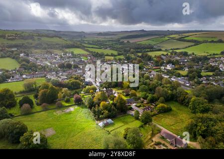 Cerne Abbas, Dorset, Großbritannien. Oktober 2024. Wetter in Großbritannien. Herbstlicher Blick aus der Luft des Dorfes Cerne Abbas in Dorset an einem warmen und meist bewölkten Morgen mit den kurzen Sonnenstrahlen. Bildnachweis: Graham Hunt/Alamy Live News Stockfoto