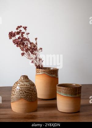 Schöne handwerkliche Töpferkomposition, Tassen und getrocknete Blumen, handgefertigt in frankreich, rustikaler Stil und heller Hintergrund Stockfoto