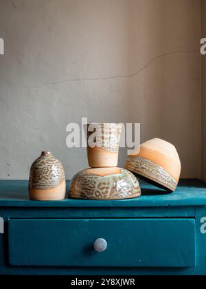 Schöne handwerkliche Töpferkomposition, Tassen, Schüsseln und Werkzeuge auf einem blauen Schrank, handgefertigt in frankreich, rustikaler Stil Stockfoto