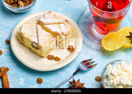 Hausgemachter Käsekuchen mit Rosinen. Käsekuchen mit Rosinen und Zitronenscheiben und Tee Stockfoto