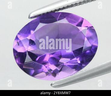 Exquisiter Amethyst Edelstein Im Ovalen Schliff, Strahlend In Leuchtendem Lila. Stockfoto