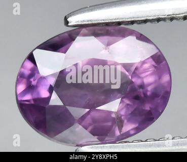 Exquisiter Amethyst-Edelstein mit ovalem Schliff in satten violetten Tönen und strahlender Klarheit. Stockfoto