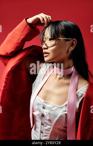 Eine stilvolle asiatische Frau posiert selbstbewusst und zeigt ihren einzigartigen Sinn für Mode und Eleganz. Stockfoto