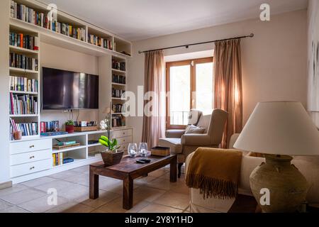 Sessel mit Bücherregalen und Fernseher in spanischer Villa auf Mallorca. Stockfoto