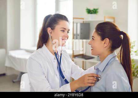 Positiver Arzt Oder Krankenschwester, Der Die Lunge Des Patienten Mit Stethoskop In Der Klinik Hört Stockfoto