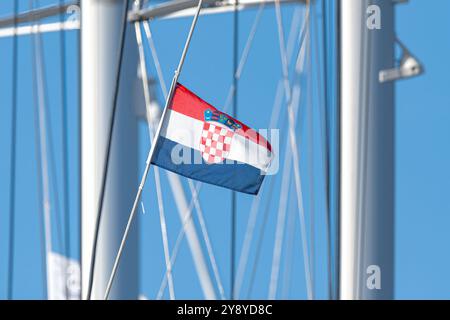 Die Nationalflagge Kroatiens winkt an einem sonnigen Tag im Wind auf dem Mast eines Segelbootes. Stockfoto