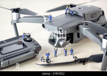 Miniaturingenieure arbeiten an einer Drohne und führen Wartungs- und Reparaturaufgaben durch Stockfoto