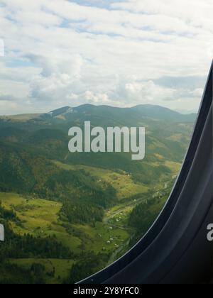 Das Flugzeug fliegt über die Berge, wunderschöne Aussicht vom Fenster Stockfoto