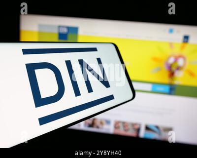 Smartphone mit Logo des Deutschen Instituts für Normung e.V. (DIN) auf dem Bildschirm vor der Website. Fokussieren Sie sich auf die linke Mitte des Telefondisplays. Stockfoto