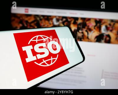 Mobiltelefon mit Logo der Internationalen Organisation für Normung (ISO) auf dem Bildschirm vor der Website. Konzentrieren Sie sich auf die Mitte des Telefondisplays. Stockfoto