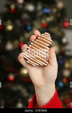Nahaufnahme von Kinderhand, die Weihnachtskuchenkeks hält Stockfoto