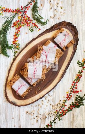 Wunderschön gewickelte hausgemachte Müsliriegel sorgen für eine gesunde und festliche Verwöhnung, perfekt für Weihnachtsgeschenke und saisonale Genüsse. Stockfoto
