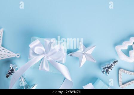 Weihnachtlicher blauer Hintergrund. Weihnachtsgeschenkkasten in blauem Papier, Kugeln, Glitzer auf blauem Hintergrund mit Platz für Ihre festliche Botschaft. Stockfoto