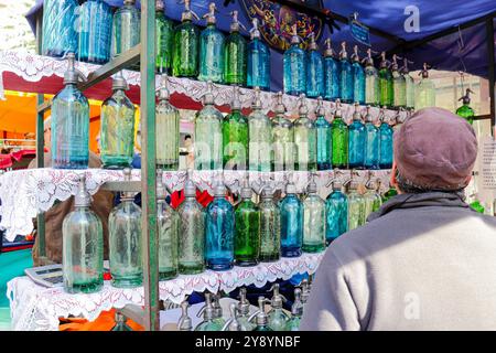 Nicht erkennbare Person, die auf der Messe San Telmo in Buenos Aires auf einen Haufen alter Soda-Siphons blickt Stockfoto