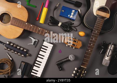 Blick von oben auf verschiedene Musikinstrumente und Geräte, einschließlich akustische und elektrische Gitarren, Tastatur, Mikrofone, Kabel und Zubehör. Me Stockfoto